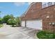 Attached two-car garage and wide driveway, set against a brick home and well-kept lawn at 9034 Kensington Forest Dr, Harrisburg, NC 28075