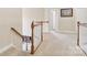 Bright hallway featuring wood and white trim staircase, neutral walls, and plush carpeting at 9034 Kensington Forest Dr, Harrisburg, NC 28075