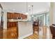 This open kitchen offers wood floors, a center island with seating, and views into the breakfast nook at 9034 Kensington Forest Dr, Harrisburg, NC 28075