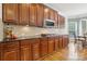 Kitchen featuring custom wood cabinetry, granite countertops, and a tiled backsplash at 9034 Kensington Forest Dr, Harrisburg, NC 28075