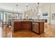 Open-concept kitchen with island, hardwood floors, and a view of the living and dining areas at 9034 Kensington Forest Dr, Harrisburg, NC 28075