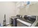 Modern laundry room with updated appliances, shelving, and tile floors at 9034 Kensington Forest Dr, Harrisburg, NC 28075