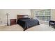 This bedroom has carpet floors, neutral walls, and a window letting in natural light at 9034 Kensington Forest Dr, Harrisburg, NC 28075
