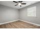 Neutral bedroom with a ceiling fan and window, complemented by wood-look flooring and white trim at 1067 Winchester Dr, Rock Hill, SC 29730