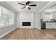 Open concept living area with modern fireplace, ceiling fan, light gray paint, and wood flooring at 1067 Winchester Dr, Rock Hill, SC 29730