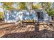Quaint blue home with small deck, surrounded by trees and autumn leaves at 108 Sailors Ct # 108 B, Mount Gilead, NC 27306