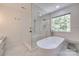 Bright bathroom featuring a freestanding tub, glass shower, and natural light at 1134 Blueberry Ln, Charlotte, NC 28226
