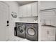Convenient laundry room is equipped with a washer, dryer, and overhead cabinets at 1134 Blueberry Ln, Charlotte, NC 28226