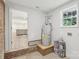 Open basement area with water heater, paint cans, and glimpse of the partially finished room beyond at 1192 Carolyn Dr # 9, Albemarle, NC 28001
