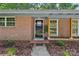 Close-up of the front entrance with a black door, brick facade, and well-kept landscaping at 1192 Carolyn Dr # 9, Albemarle, NC 28001
