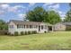 Charming one-story house with a well-kept lawn, complemented by a covered carport, and a blue cloudy sky at 127 Leonidas St, Fort Mill, SC 29715