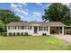 Charming white brick ranch-style home with a well-maintained lawn and covered parking at 127 Leonidas St, Fort Mill, SC 29715