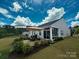 Landscaped backyard featuring a patio with seating, and a view of the screened-in porch at 1456 Augustus Beamon Dr, Indian Trail, NC 28079