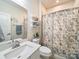 Well-lit bathroom with modern vanity, neutral color palette, and elegant floral patterned shower curtain at 1456 Augustus Beamon Dr, Indian Trail, NC 28079