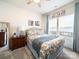 Well-lit bedroom with floral comforter, side table, and decoratively framed window at 1456 Augustus Beamon Dr, Indian Trail, NC 28079