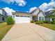 Charming single-story home featuring a two-car garage, well-manicured lawn and a concrete driveway at 1456 Augustus Beamon Dr, Indian Trail, NC 28079