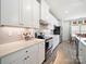 Modern kitchen boasting white cabinets, stainless steel appliances, and quartz countertops with stylish backsplash at 1456 Augustus Beamon Dr, Indian Trail, NC 28079