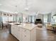 Open-concept living area with a kitchen island, flowing into a living space with neutral tones and ample natural light at 1456 Augustus Beamon Dr, Indian Trail, NC 28079