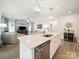 Inviting open-concept living space with a kitchen island, comfortable seating, and modern lighting fixtures at 1456 Augustus Beamon Dr, Indian Trail, NC 28079
