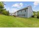This home features a spacious backyard, blue siding, lush green lawn, and brick grill at 15630 Oleander Dr, Charlotte, NC 28278
