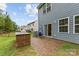 Private backyard with custom grilling station, patio, and a cozy hanging chair on a brick patio at 15630 Oleander Dr, Charlotte, NC 28278