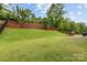 Expansive backyard with lush lawn, terraced landscaping, outdoor grilling area and hanging chair for relaxing at 15630 Oleander Dr, Charlotte, NC 28278