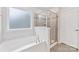 Clean bathroom featuring a shower with glass door and a soaking tub at 15630 Oleander Dr, Charlotte, NC 28278