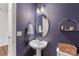 Elegant bathroom features a pedestal sink, an oval mirror, and dark blue walls at 15630 Oleander Dr, Charlotte, NC 28278