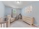 Serene blue bedroom with a crib, armchair, and dresser, perfect for a Bedroom at 15630 Oleander Dr, Charlotte, NC 28278