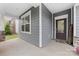 Inviting covered front porch with stylish gray siding, a modern front door, and stone accents at 15630 Oleander Dr, Charlotte, NC 28278