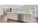 Bright kitchen features white cabinets, stainless steel appliances, island with sink, and hardwood floors at 15630 Oleander Dr, Charlotte, NC 28278