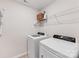 Functional laundry room equipped with modern washer and dryer units and storage shelves at 15630 Oleander Dr, Charlotte, NC 28278