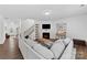 Comfortable living room with fireplace, stairs, large sectional sofa, and bright light at 15630 Oleander Dr, Charlotte, NC 28278