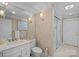 Bathroom featuring a marble vanity, framed mirror, modern lighting, and glass-enclosed shower at 17938 John Connor Rd, Cornelius, NC 28031