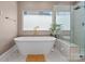 Modern bathroom featuring a soaking tub, frameless glass shower and modern gold fixtures at 17938 John Connor Rd, Cornelius, NC 28031