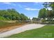 Beautiful lakeside beach on a sunny day, surrounded by mature trees at 17938 John Connor Rd, Cornelius, NC 28031