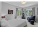 Comfortable bedroom features neutral tones, two large windows, a cozy chair and well-placed lighting at 17938 John Connor Rd, Cornelius, NC 28031