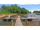 Lake dock with kayaks and bench, surrounded by mature trees, on a sunny day at 17938 John Connor Rd, Cornelius, NC 28031