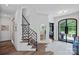 Bright foyer with modern staircase, white walls, elegant flooring, and a view into the adjacent living spaces at 17938 John Connor Rd, Cornelius, NC 28031