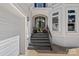 Elegant front entrance featuring a black arched doorway, brick steps, and a two-car garage at 17938 John Connor Rd, Cornelius, NC 28031