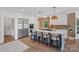 Modern, white kitchen featuring a large center island with seating, stainless steel appliances, and pendant lighting at 17938 John Connor Rd, Cornelius, NC 28031