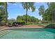 Poolside lounge area with a lake view and a beautifully landscaped backyard at 17938 John Connor Rd, Cornelius, NC 28031