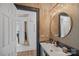 Elegant powder room featuring a round mirror, textured wallpaper, and designer fixtures at 17938 John Connor Rd, Cornelius, NC 28031
