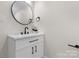 Bathroom featuring a modern vanity with a round mirror and a black faucet at 18 S Coulter Ave, Newton, NC 28658
