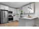 Modern kitchen featuring stainless steel appliances, white cabinetry, and light hardwood flooring at 18 S Coulter Ave, Newton, NC 28658