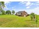 Expansive backyard featuring a brick home, lush green lawn and mature trees at 1825 Smyre Farm Rd, Newton, NC 28658