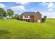 Spacious backyard showcasing a brick home, deck, and expansive green space at 1825 Smyre Farm Rd, Newton, NC 28658