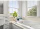 Bright bathroom featuring a luxurious soaking tub and a large window bringing in natural light and views of the outdoors at 1825 Smyre Farm Rd, Newton, NC 28658