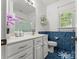 Bathroom with white vanity, blue tile, decorative mirror and sliding shower doors at 1825 Smyre Farm Rd, Newton, NC 28658