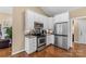Modern kitchen featuring stainless steel appliances, white cabinets, tile backsplash, and hardwood flooring for a sleek design at 1825 Smyre Farm Rd, Newton, NC 28658